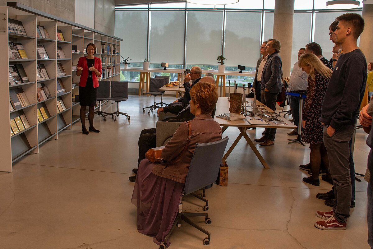 Izstādes atklāšanas brīdis - LU Bibliotēkas bibliotekāre Marta Liepa pasākuma dalībniekus iepazīstina ar izstādes saturu. Foto: Maija Sjomkāne, LU FMOF Skaitliskās modelēšanas institūta zinātniskā asistente.