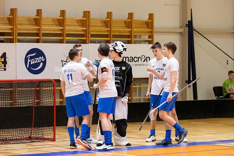 Florbola komanda, ieskaitot vārtsargu, priecājas par veiksmīgu spēles momentu