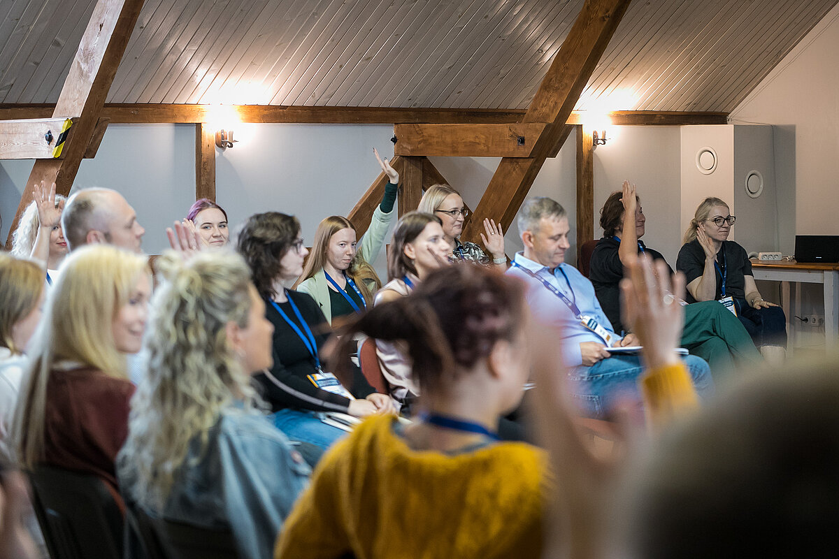 Foto: Toms Grīnbergs, LU Komunikācijas departaments Cilvēki auditorijā, daļa pacēluši rokas un balso par kādu jautājumu