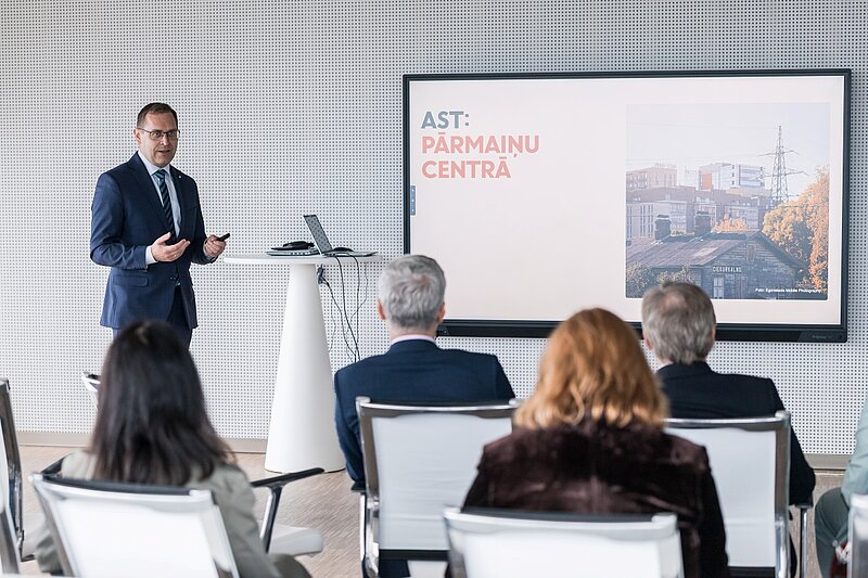 AST valdes priekšsēdētājs Rolands Irklis. Fonā prezentācija. 