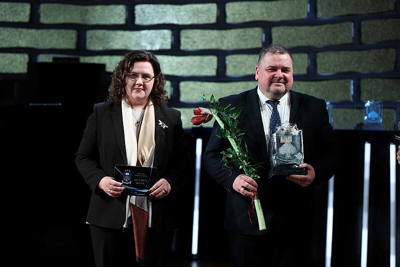 Kristīne Strada-Rozenberga un Edmundas Trumpa LU Lielajā aulā. E. Trumpa tur rokā LU Izcilības balvu