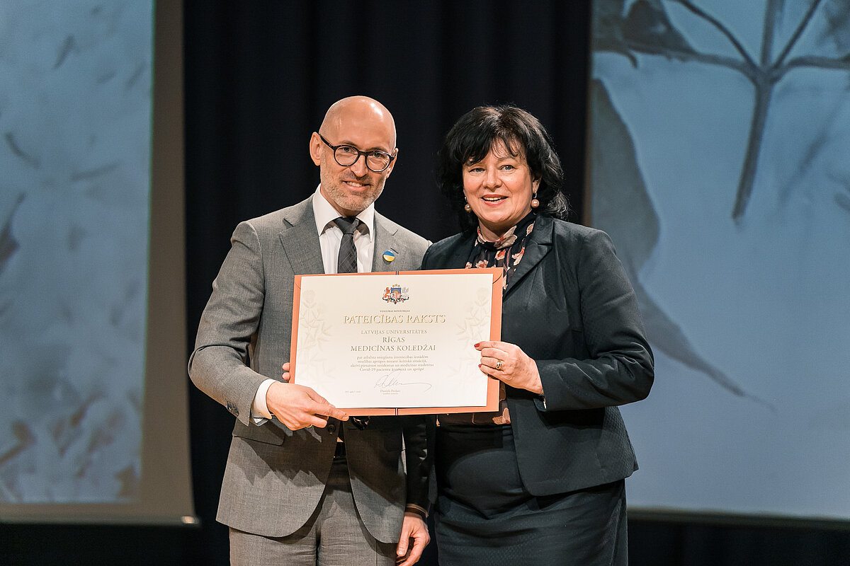 Minister of Health Daniels Pavļuts presents a certificate of recognition to Sarmīte Villere, Deputy Director for Education at the Riga Medical College of the University of Latvia 