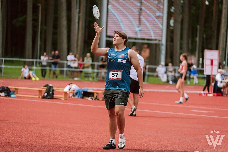 Sportists gatavojas mest disku tālumā