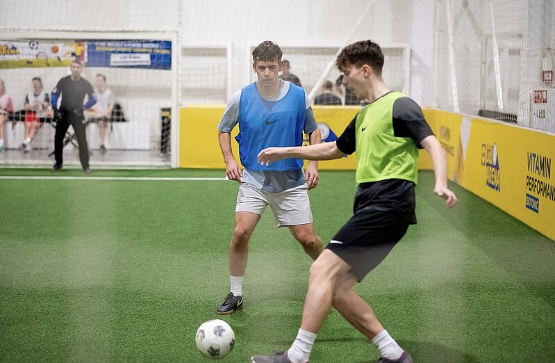 Futbola spēle, vīrietis sper pa bumbu