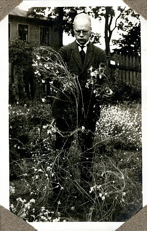 A. Zāmelis pie krustziežu dzimtas auga. Fotogrāfija no A. Zāmeļa disertācijas «Ģinšu un sugu krustošanas mēģinājumi krustziežu dzimtā» pielikuma. Fotogrāfs: E. Kālis, 1928. gads. LU Muzeja krājums
