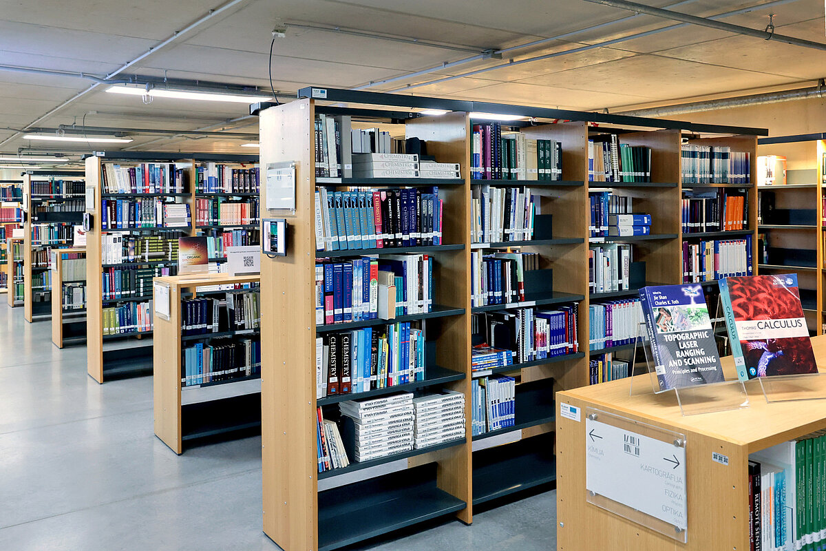Bibliotēkas plaukti ar grāmatām