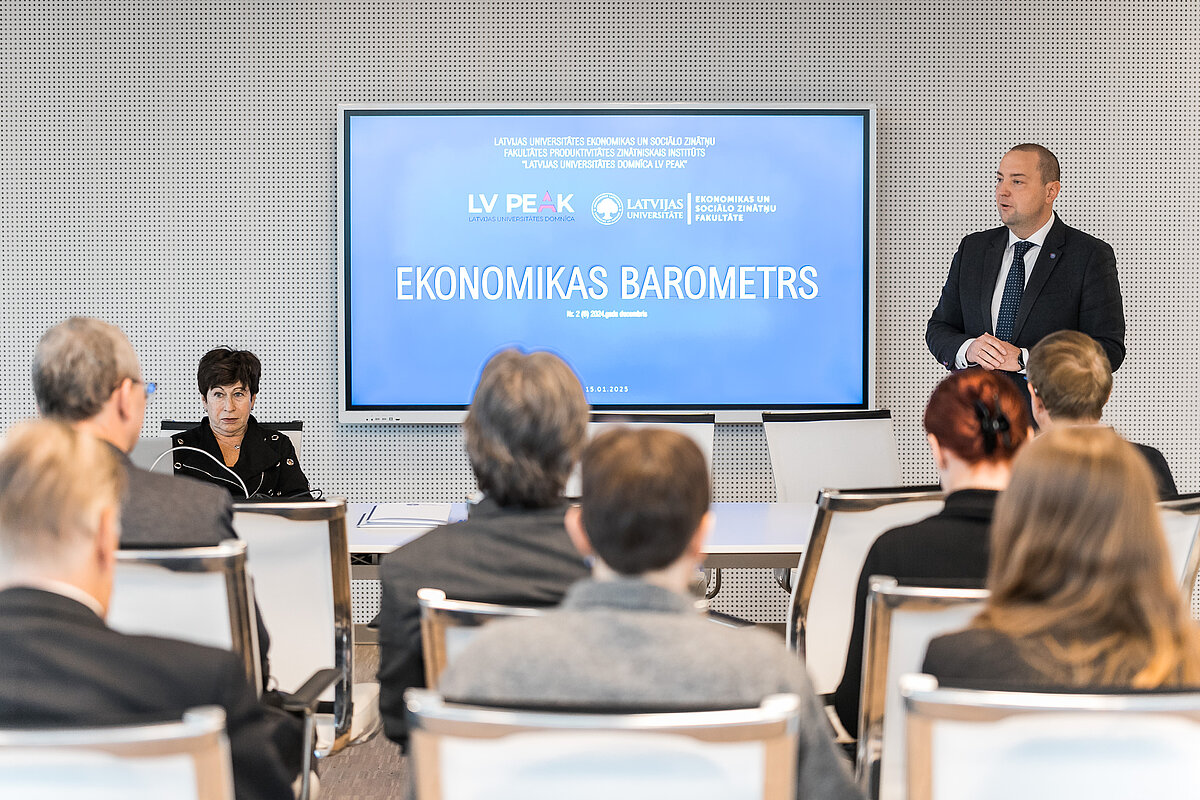 Lektors auditorijas priekšā prezentē pētījumu