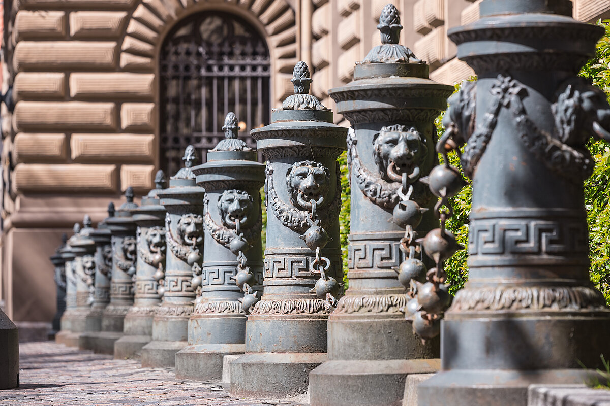 A row of decorative metal poles with an animal's head