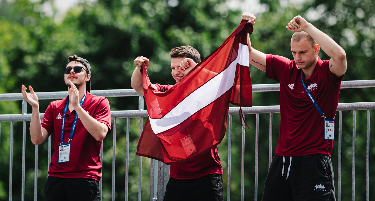LU sportisti Pasaules Vasaras Universiādē Vācijā. Sportisti tur rokās Latvijas karogu