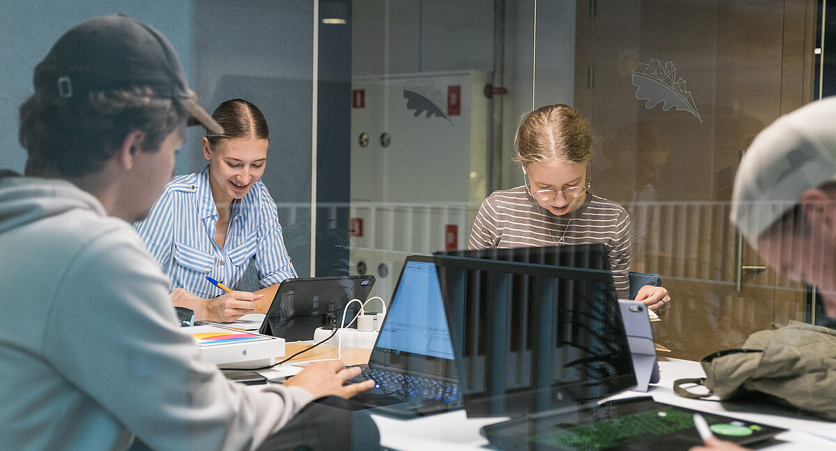 Studenti pie galda ar datoriem