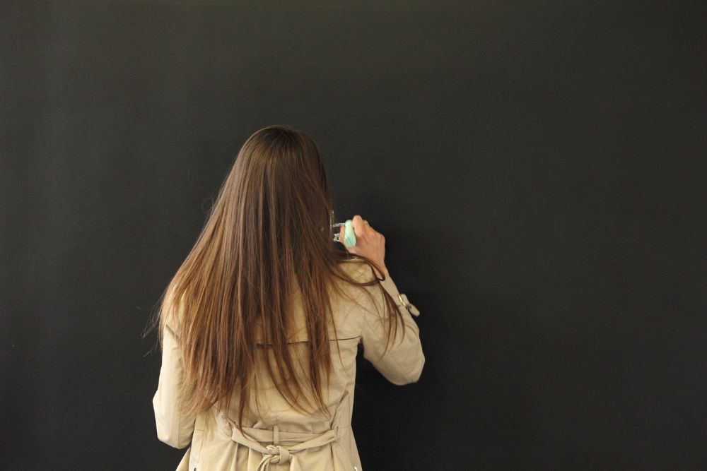 Sieviete raksta uz tāfeles