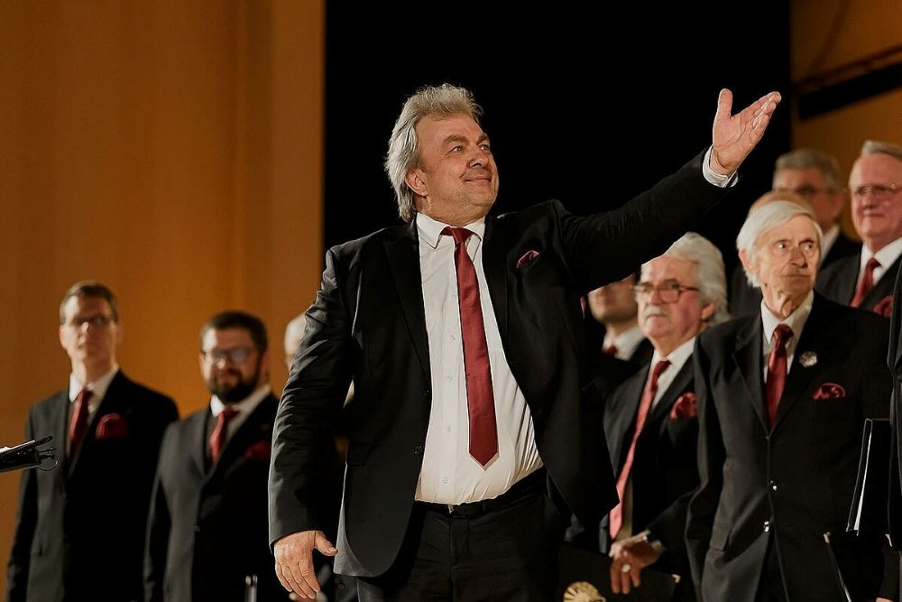 LU vīru kora “Dziedonis” mākslinieciskais vadītājs, Vispārējo latviešu dziesmu un deju svētku virsdiriģents Uldis Kokars priekšplānām, fonā koris