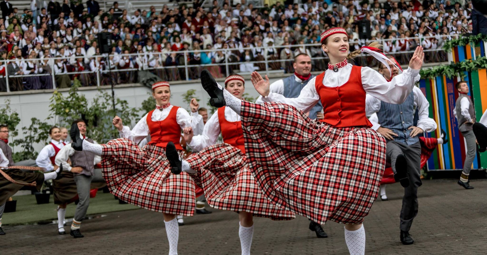 Dejotāji tautastērpos uzstājas, izpildot deju skatītāju priekšā.